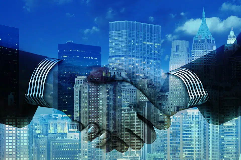 Depiction of a handshake with a skyline overlaid the image