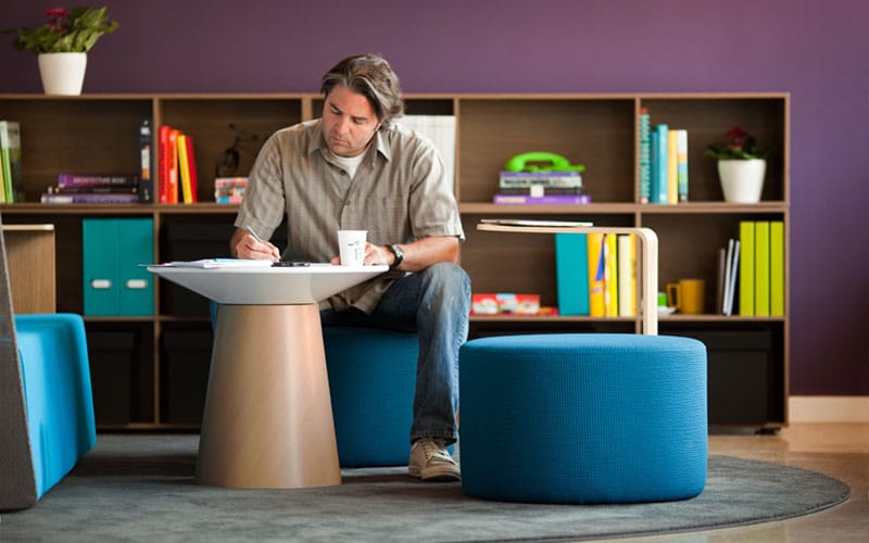 Worker sitting on ottoman in front of statement wall