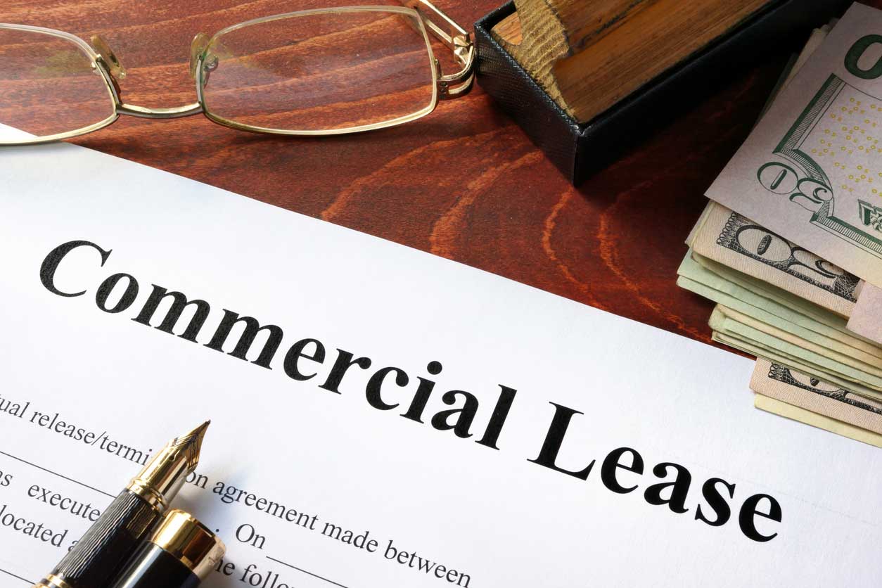 Image depicting a commercial office space with a "Lease Agreement" document in focus, representing the importance of understanding commercial leases.